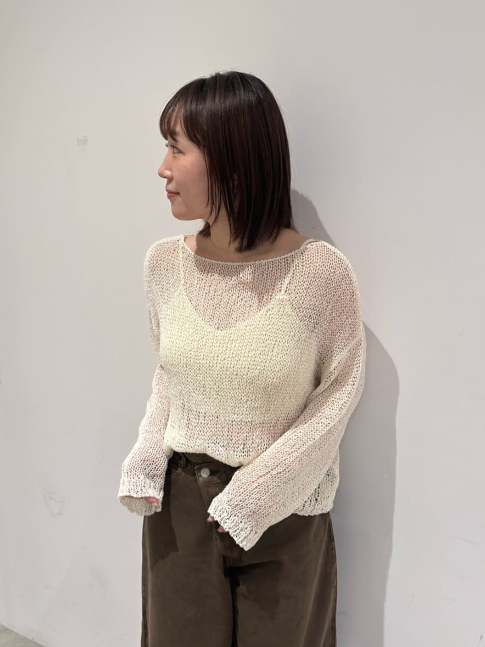 ホワイト系のニット/セーター、ブラウン系のデニムパンツを着用したレディースの秋コーディネートの4枚目の写真