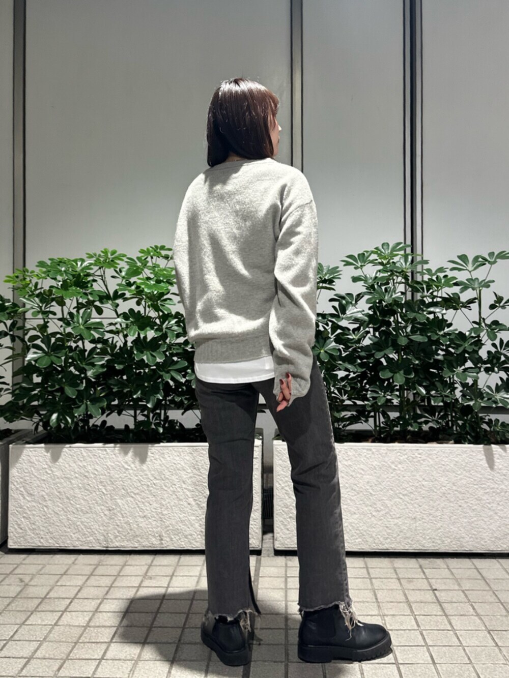 グレー系のニット/セーター、ブラック系のデニムパンツを着用したレディースの秋コーディネートの6枚目の写真