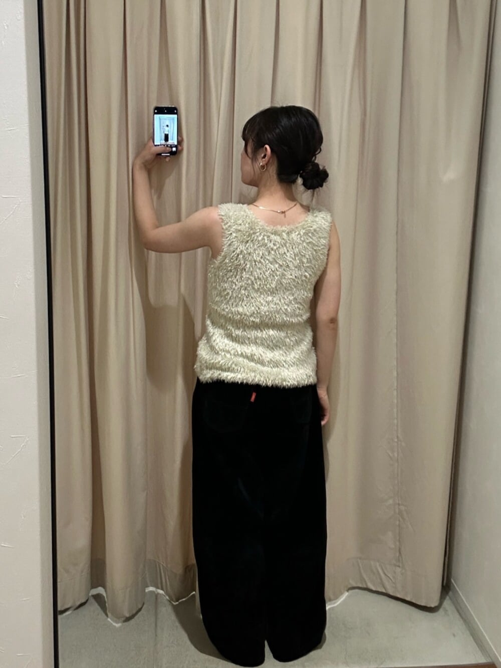 ゴールド系のニット/セーター、ブラック系のデニムパンツを着用したレディースの夏コーディネートの5枚目の写真