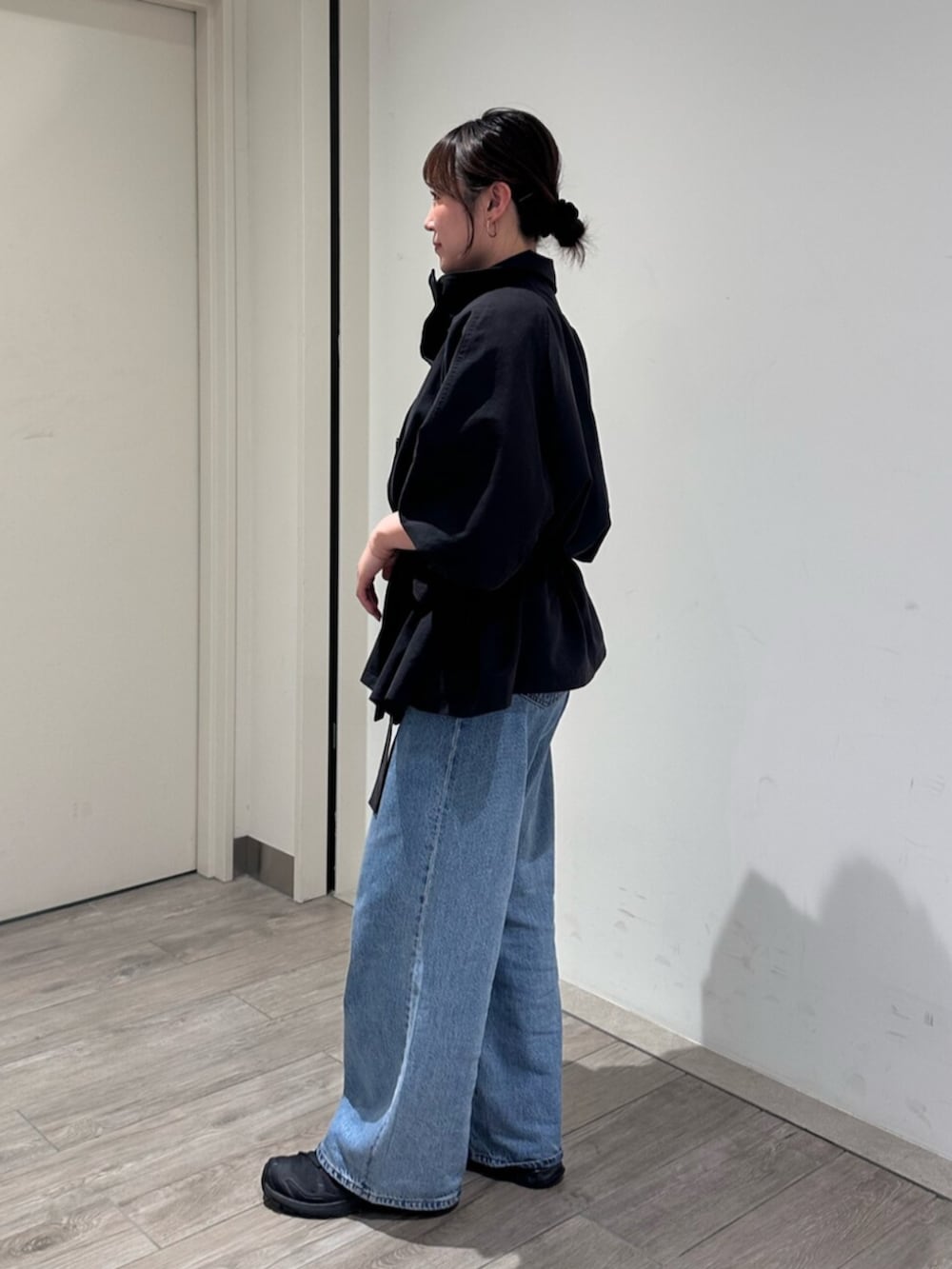 ブルー系のデニムパンツ、グレー系のトレンチコートを着用したレディースの秋コーディネートの2枚目の写真