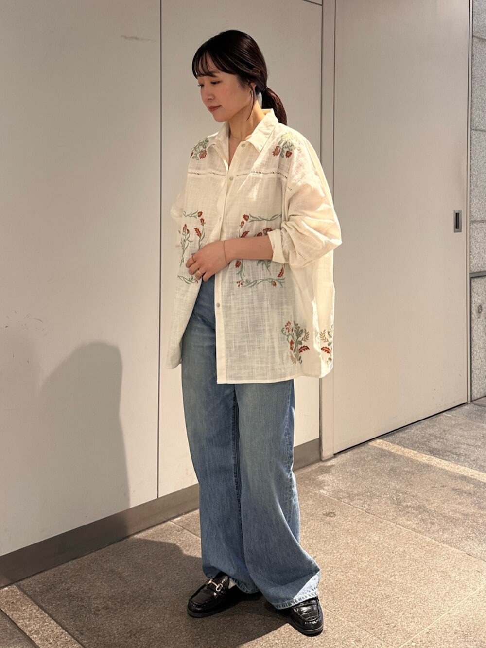 ブルー系のデニムパンツ、ホワイト系のシャツ/ブラウスを着用したレディースの春コーディネートの2枚目の写真