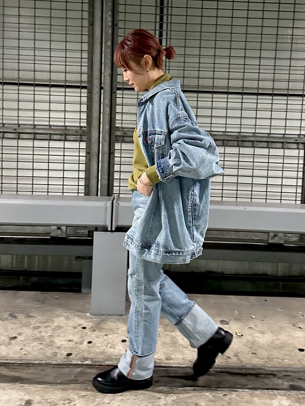 グリーン系のスウェット、ブルー系のデニムパンツを着用したレディースの冬コーディネートの5枚目の写真