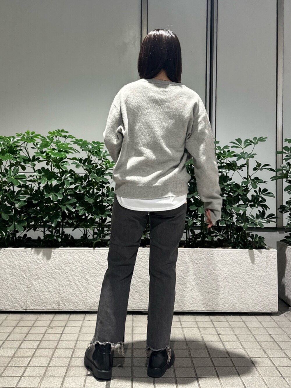 グレー系のニット/セーター、ブラック系のデニムパンツを着用したレディースの秋コーディネートの5枚目の写真