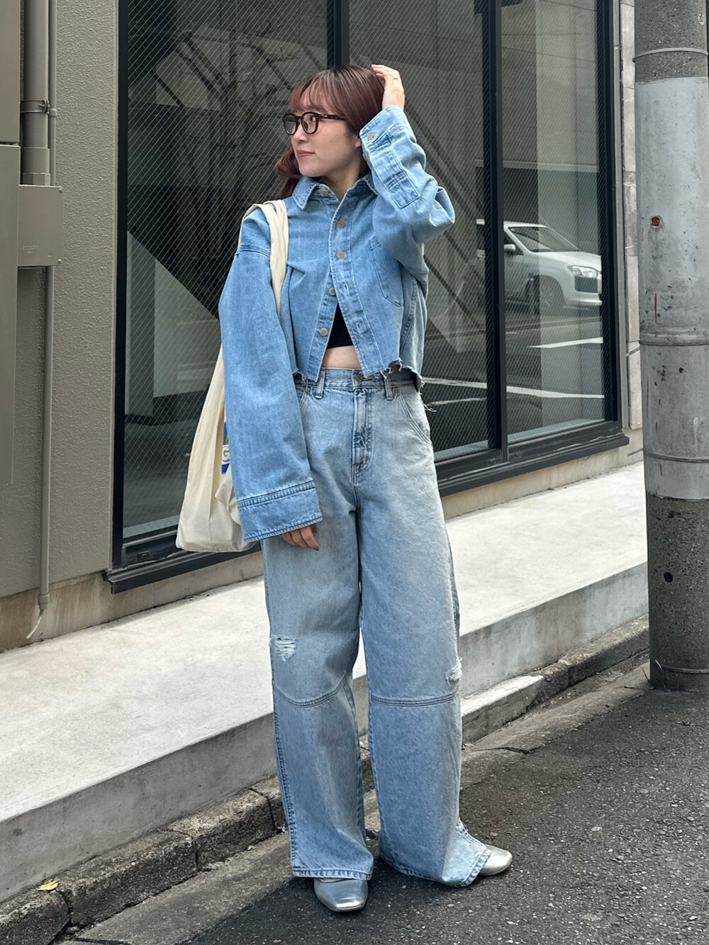 ブルー系のシャツ/ブラウス、ブルー系のデニムパンツ、ホワイト系のエコバッグ/サブバッグを着用したレディースの冬コーディネートの2枚目の写真