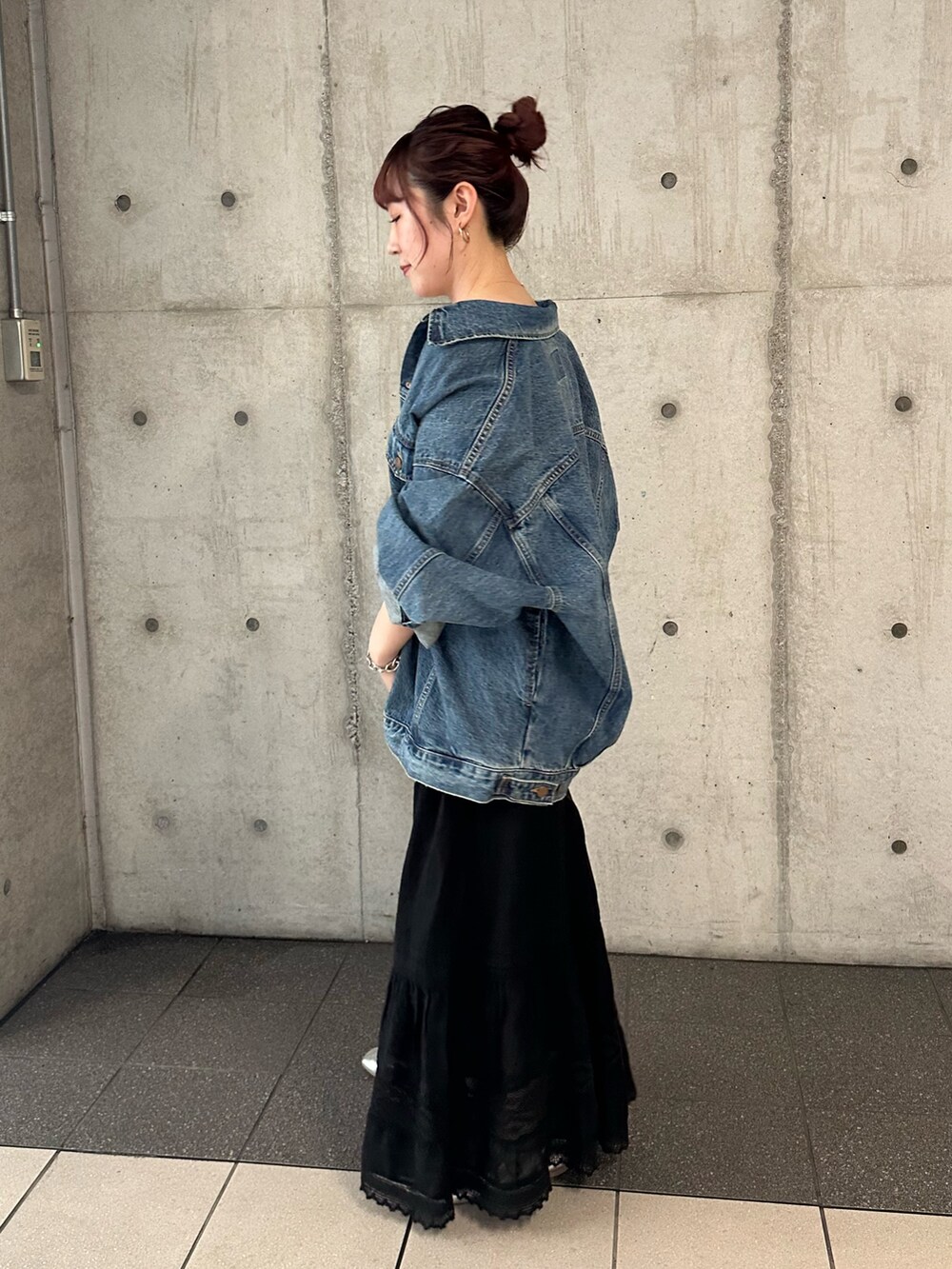 ブルー系のデニムジャケット、ブラック系のスカートを着用したレディースの夏コーディネートの2枚目の写真