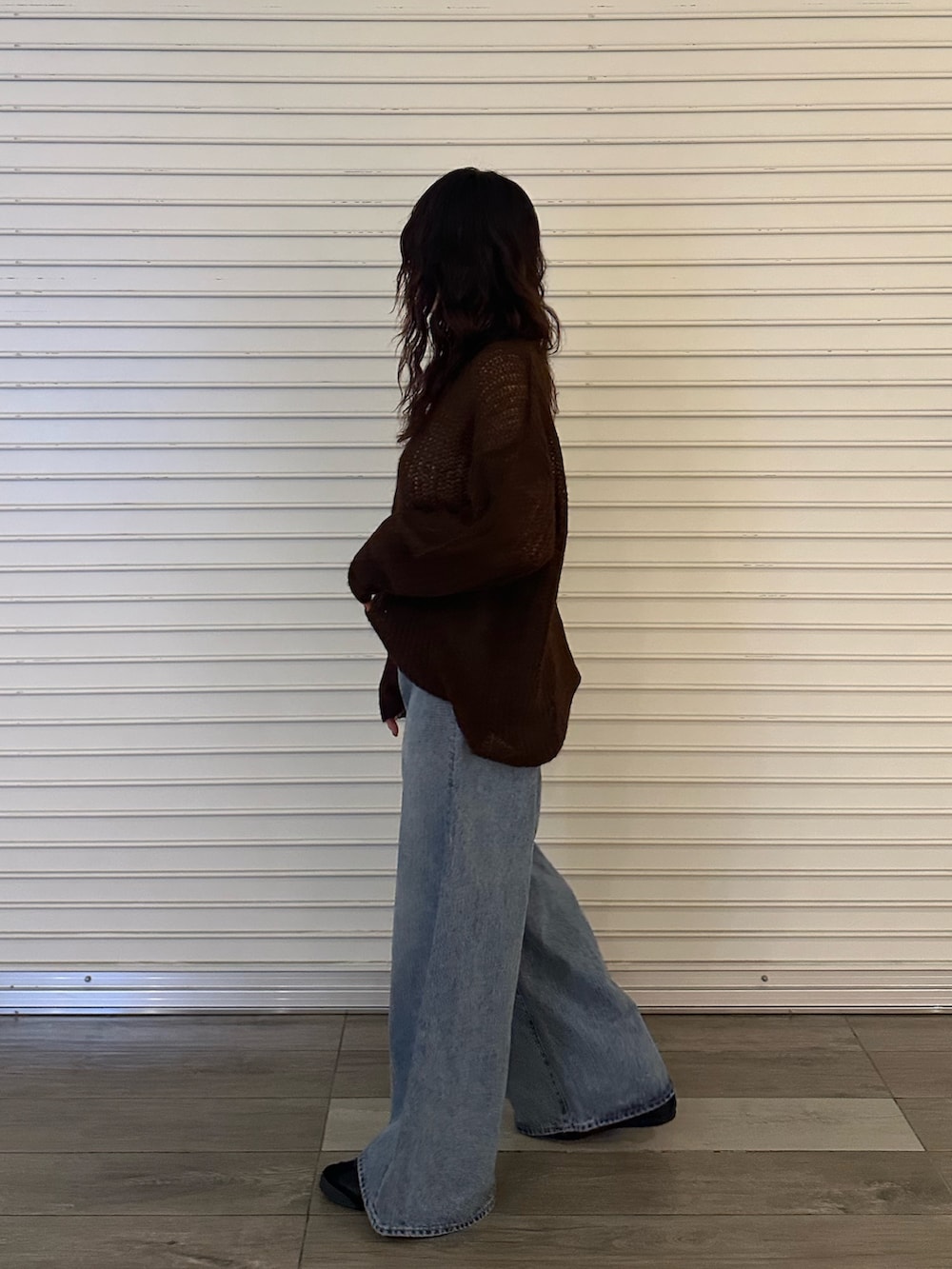 ブラウン系のニット/セーター、ブルー系のデニムパンツを着用したレディースの秋コーディネートの2枚目の写真