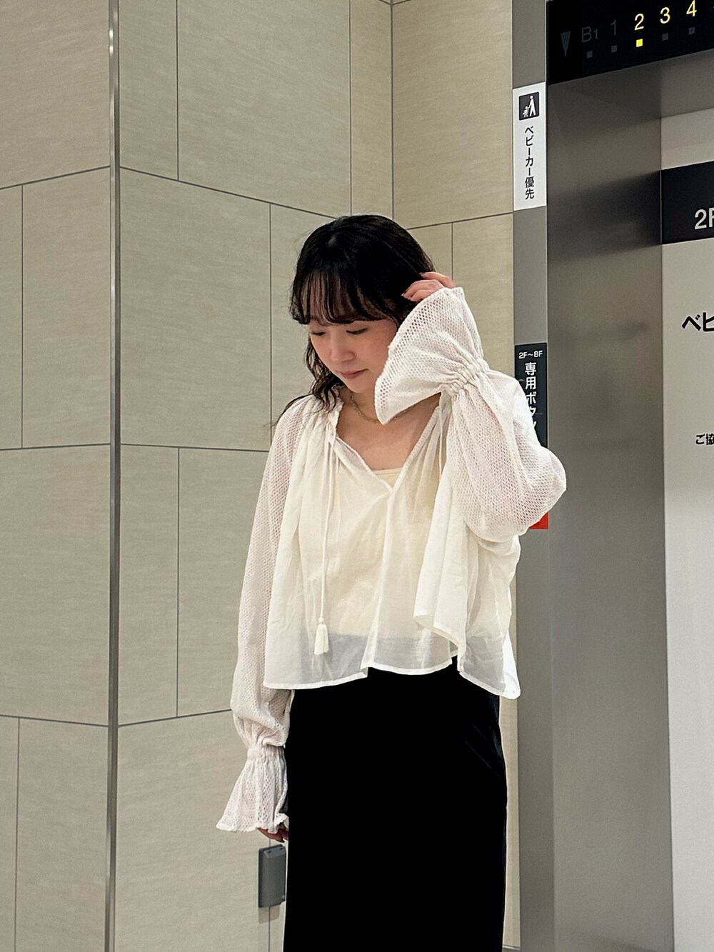 ホワイト系のシャツ/ブラウス、ブラック系のスカートを着用したレディースの秋コーディネートの6枚目の写真