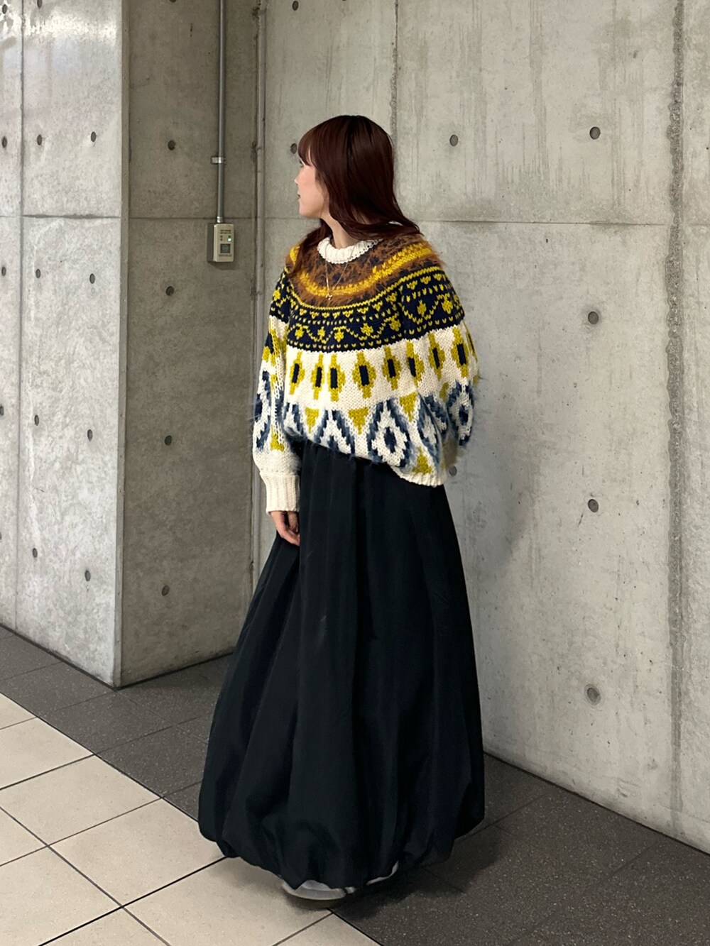 ホワイト系のニット/セーター、ブラック系のスカートを着用したレディースの冬コーディネートの2枚目の写真