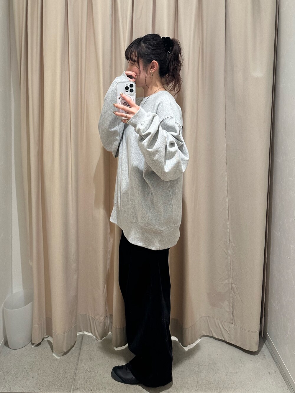 グレー系のスウェット、ブラック系のデニムパンツを着用したレディースの秋コーディネートの4枚目の写真