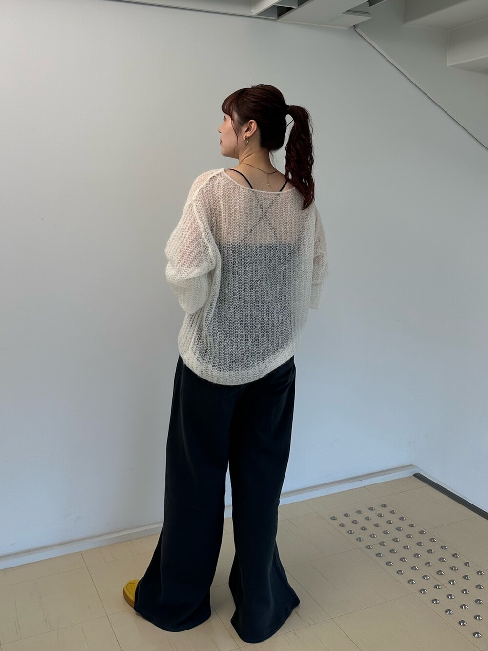 ホワイト系のニット/セーター、グレー系のスウェットパンツを着用したレディースの秋コーディネートの5枚目の写真