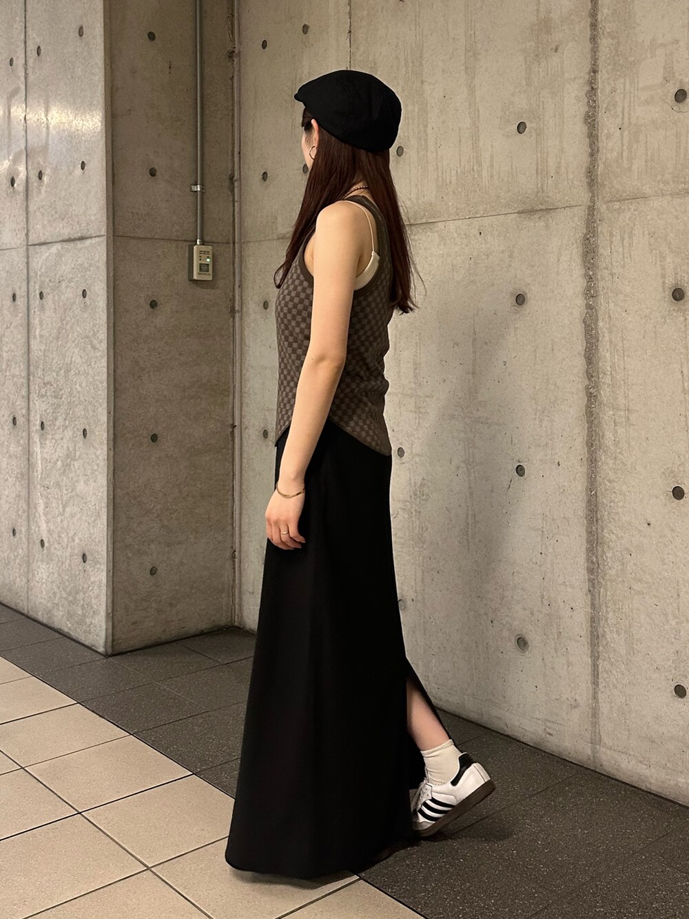 ブラウン系のタンクトップ、ブラック系のスカート、ブラック系のハンチング/ベレー帽を着用したレディースの春コーディネートの3枚目の写真