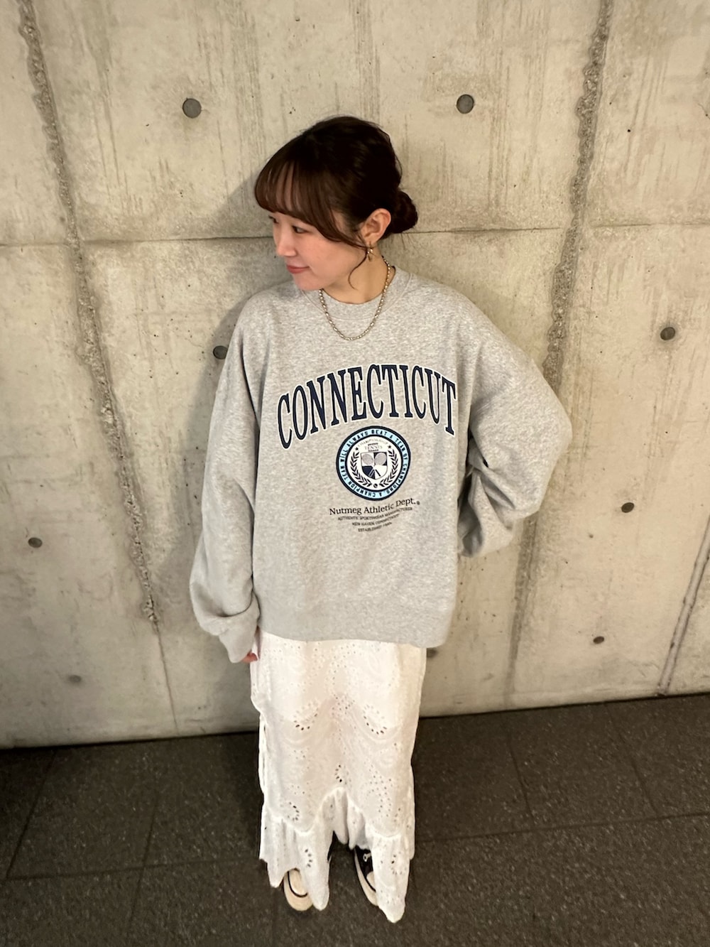 グレー系のスウェット、ホワイト系のスカートを着用したレディースの冬コーディネートの6枚目の写真