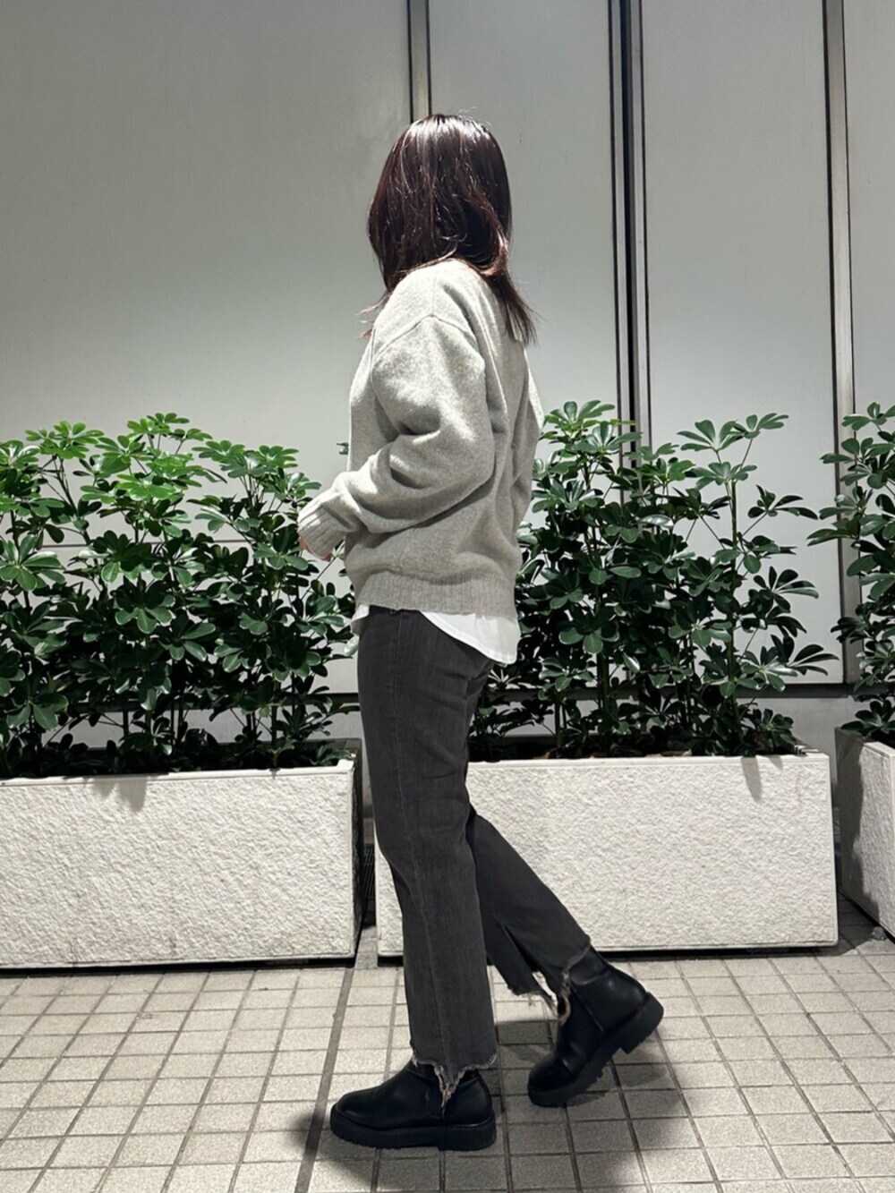 グレー系のニット/セーター、ブラック系のデニムパンツを着用したレディースの秋コーディネートの3枚目の写真