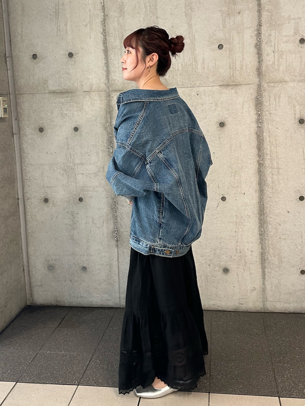 ブルー系のデニムジャケット、ブラック系のスカートを着用したレディースの夏コーディネートの3枚目の写真