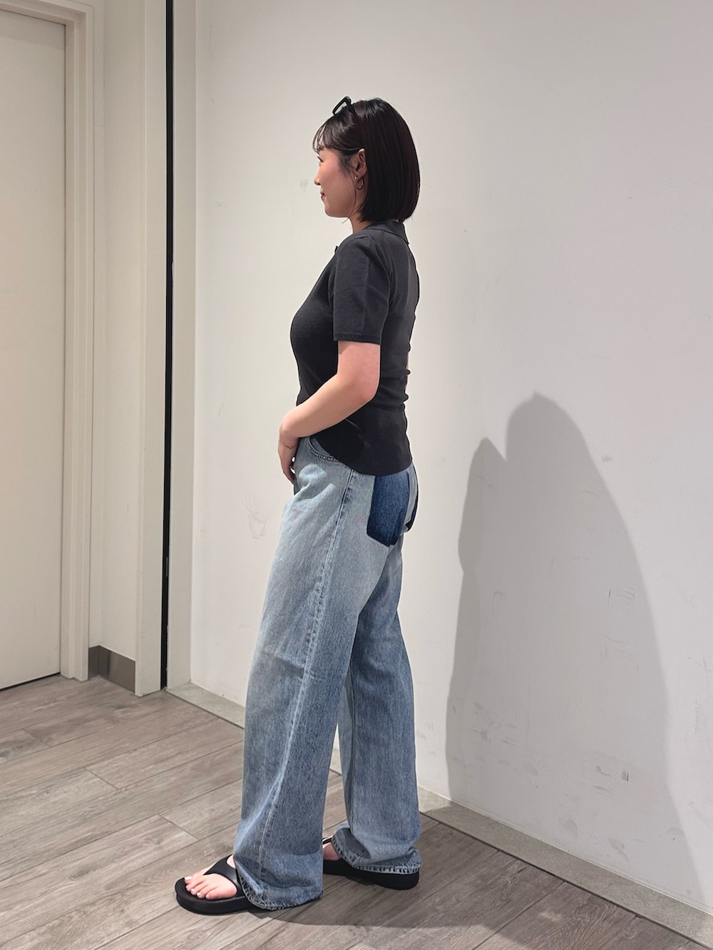 グレー系のニット/セーター、ブルー系のデニムパンツを着用したレディースの夏コーディネートの2枚目の写真
