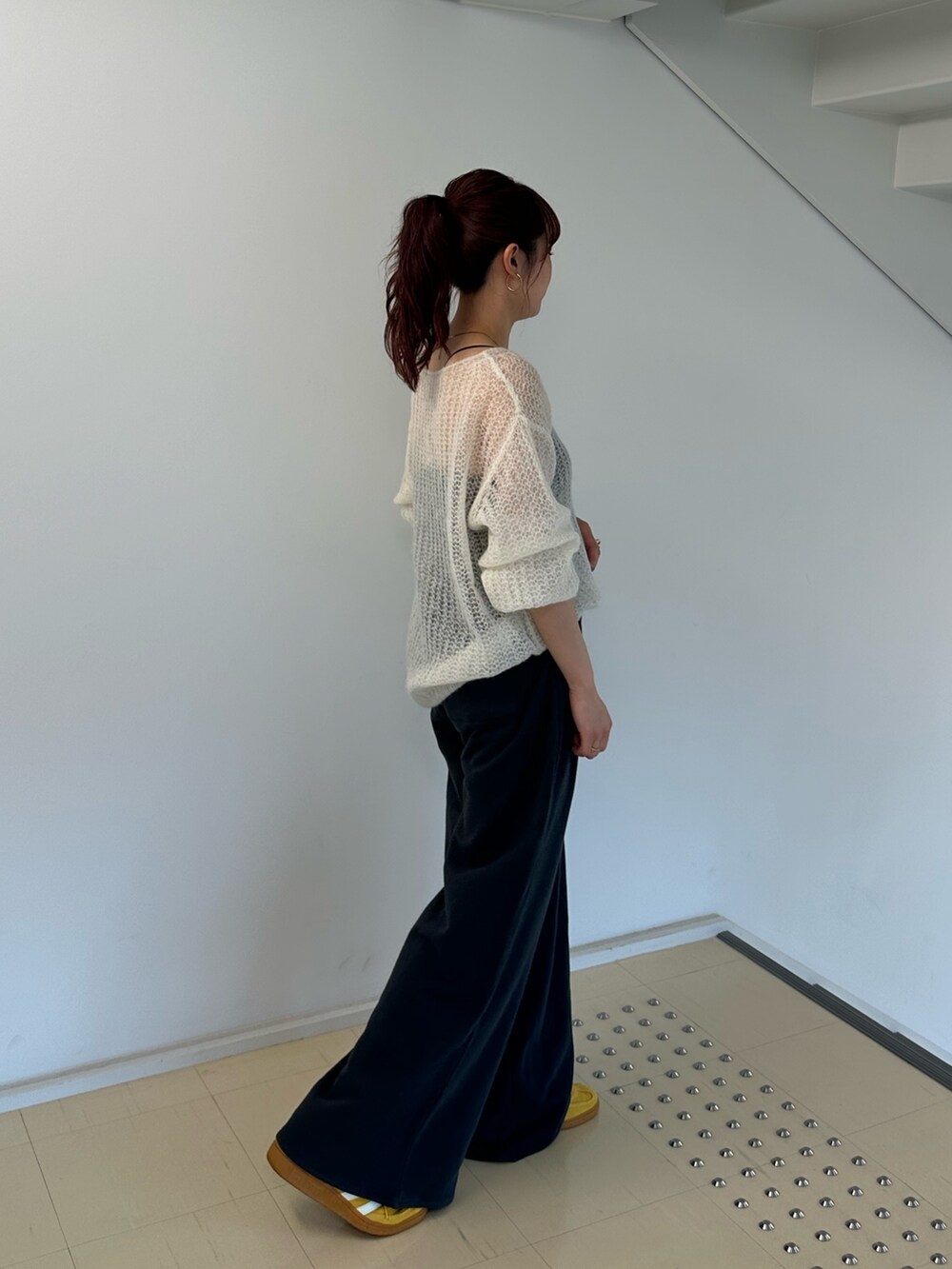 ホワイト系のニット/セーター、グレー系のスウェットパンツを着用したレディースの秋コーディネートの3枚目の写真