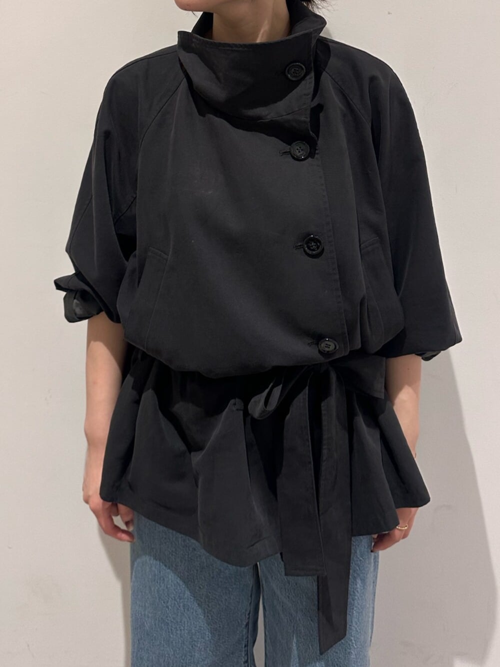 ブルー系のデニムパンツ、グレー系のトレンチコートを着用したレディースの秋コーディネートの5枚目の写真