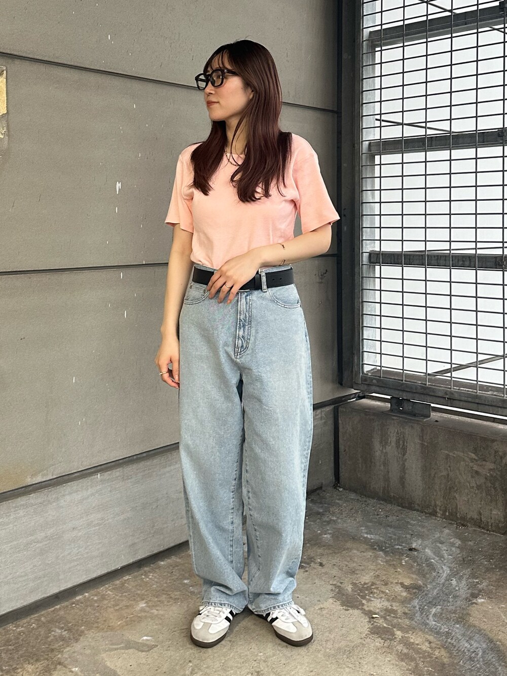 ピンク系のTシャツ/カットソー、ブルー系のデニムパンツを着用したレディースの春コーディネートの2枚目の写真