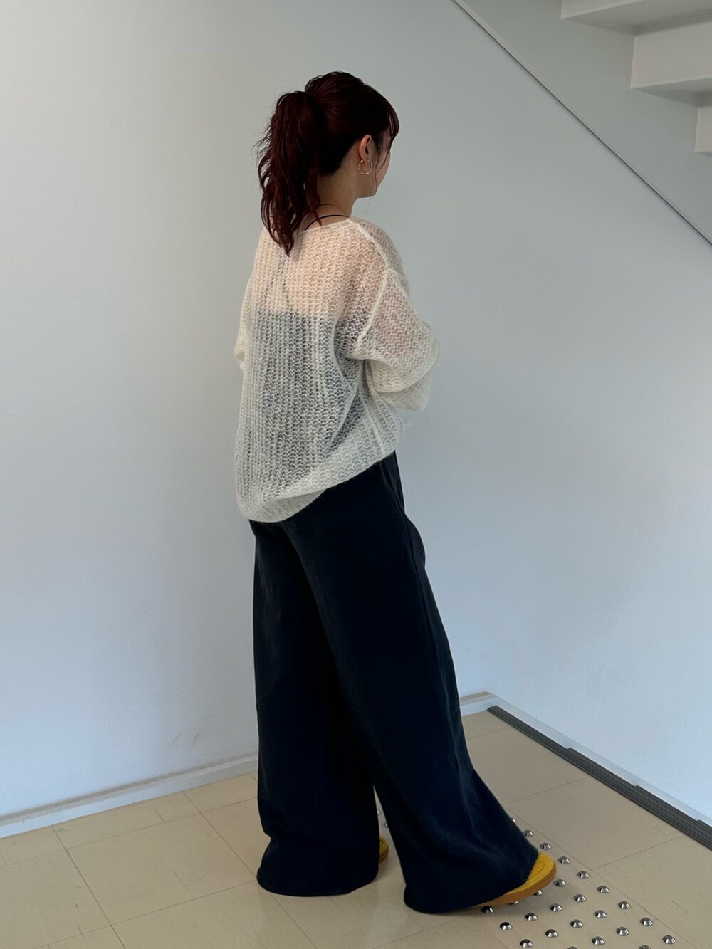 ホワイト系のニット/セーター、グレー系のスウェットパンツを着用したレディースの秋コーディネートの4枚目の写真