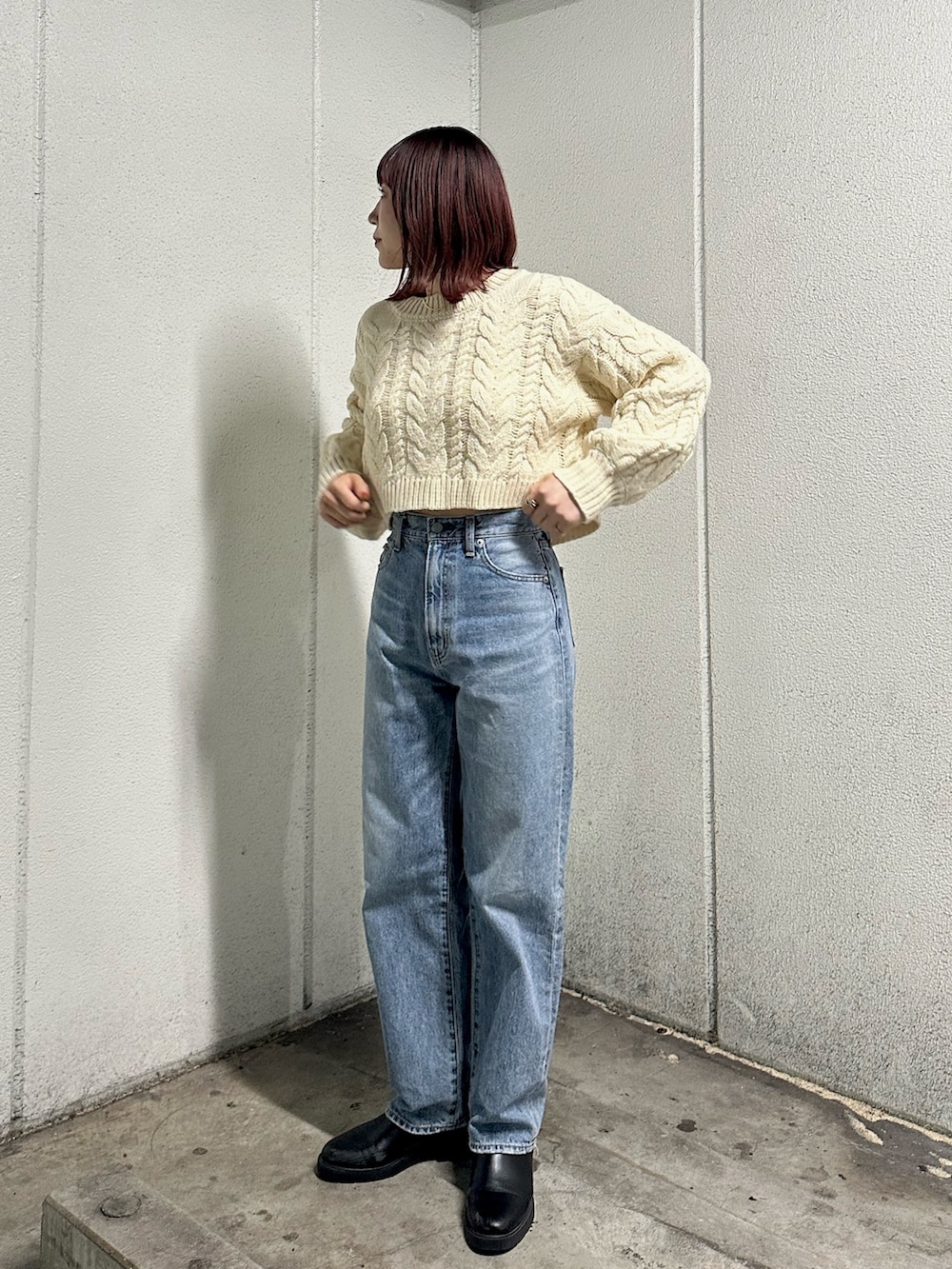 ホワイト系のニット/セーター、ブルー系のデニムパンツを着用したレディースの冬コーディネートの2枚目の写真