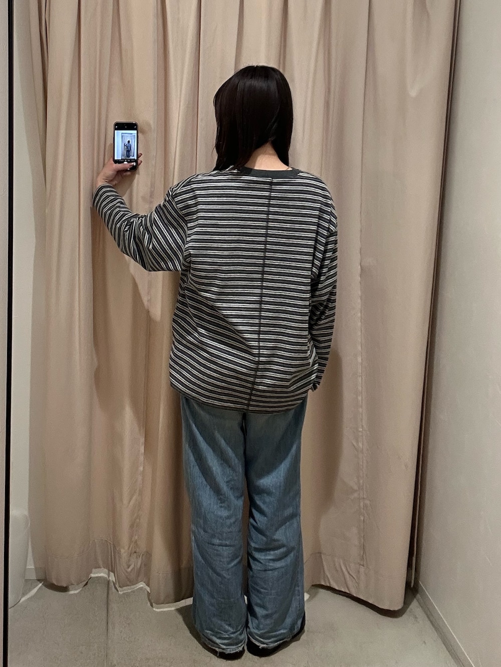 グレー系のTシャツ/カットソー、ブルー系のデニムパンツを着用したレディースの冬コーディネートの4枚目の写真