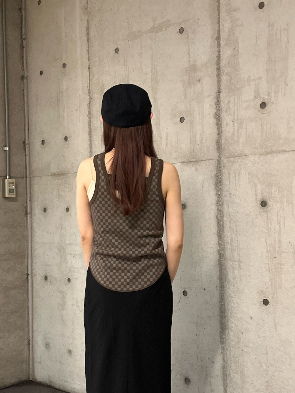 ブラウン系のタンクトップ、ブラック系のスカート、ブラック系のハンチング/ベレー帽を着用したレディースの春コーディネートの5枚目の写真
