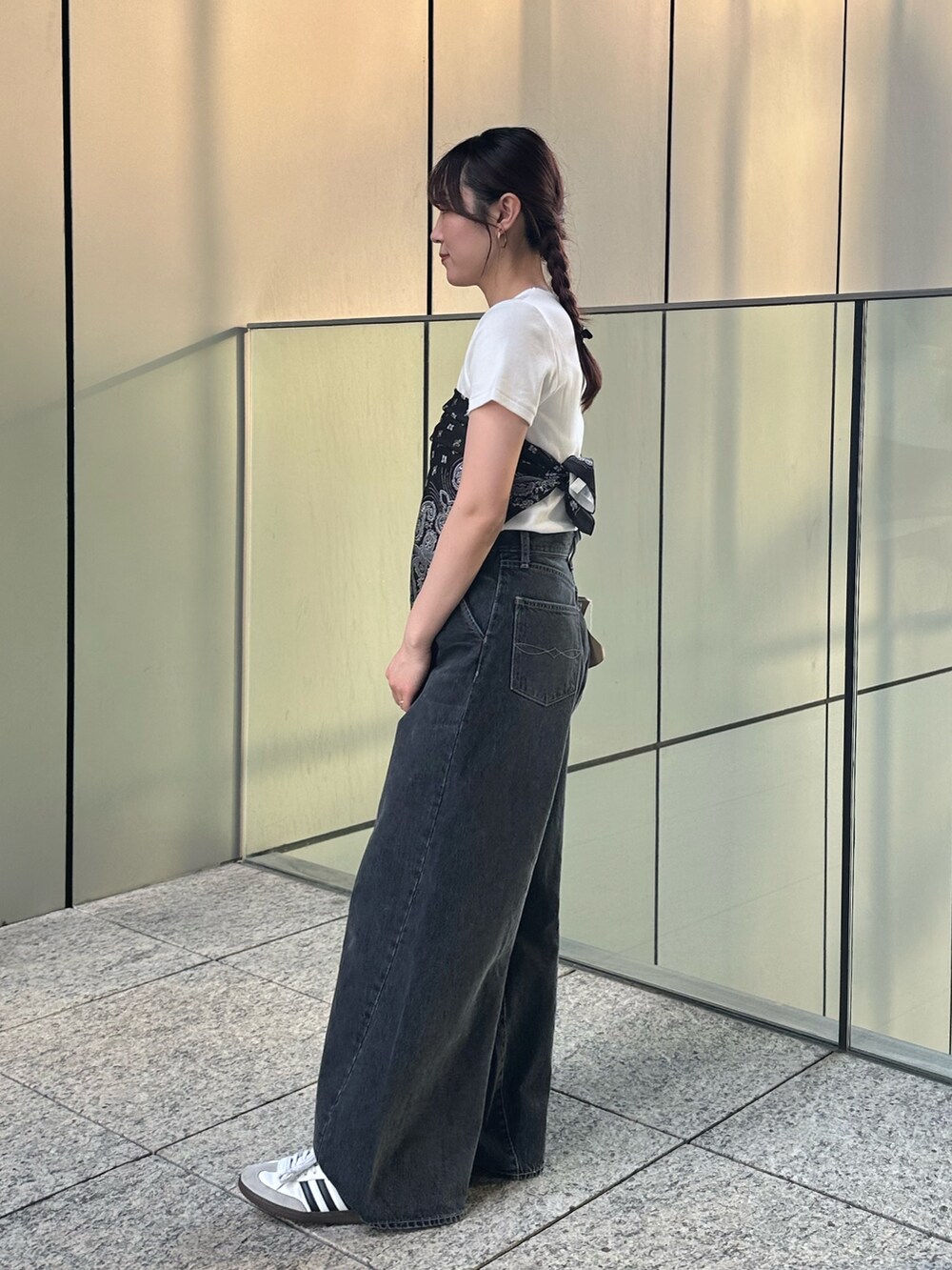 ホワイト系のTシャツ/カットソー、ブラック系のデニムパンツ、ブラック系のストール/ショールを着用したレディースの春コーディネートの4枚目の写真