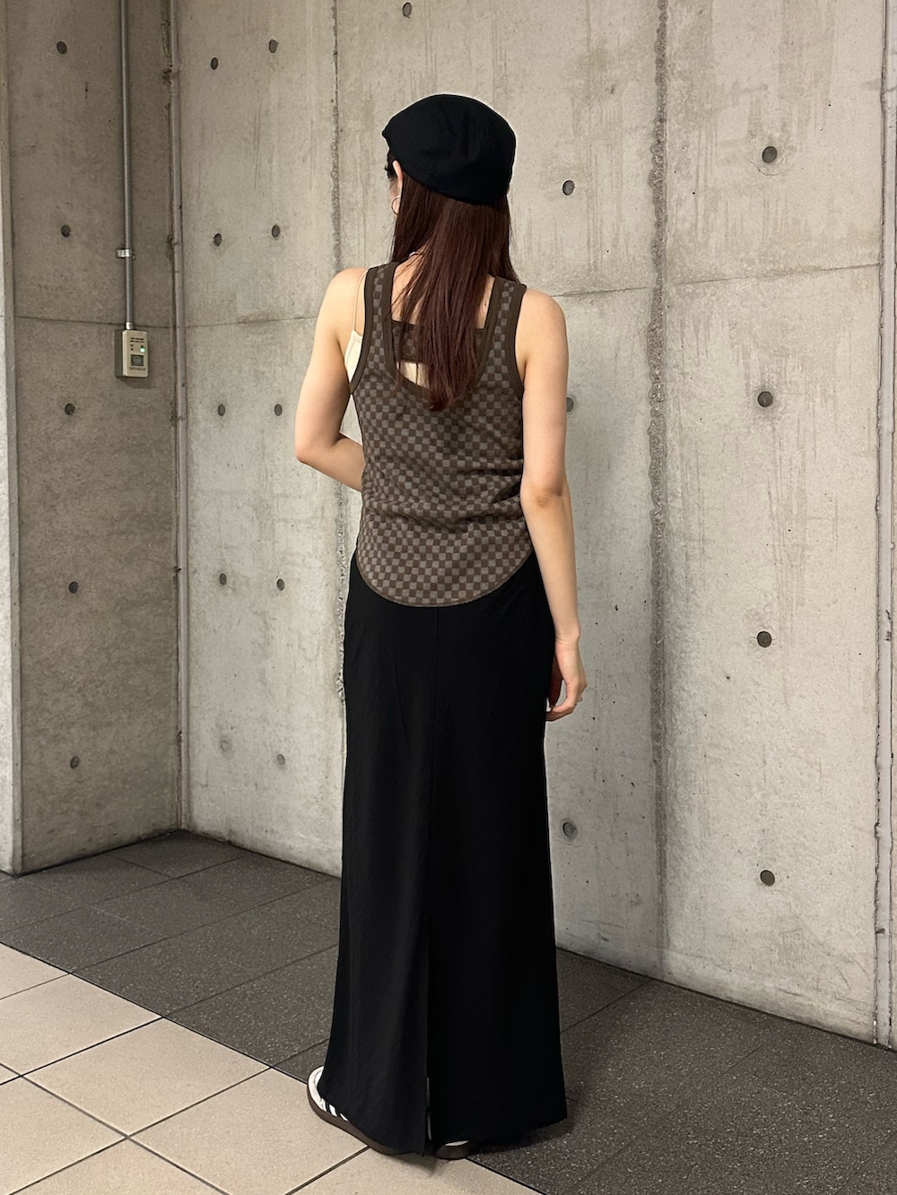 ブラウン系のタンクトップ、ブラック系のスカート、ブラック系のハンチング/ベレー帽を着用したレディースの春コーディネートの4枚目の写真