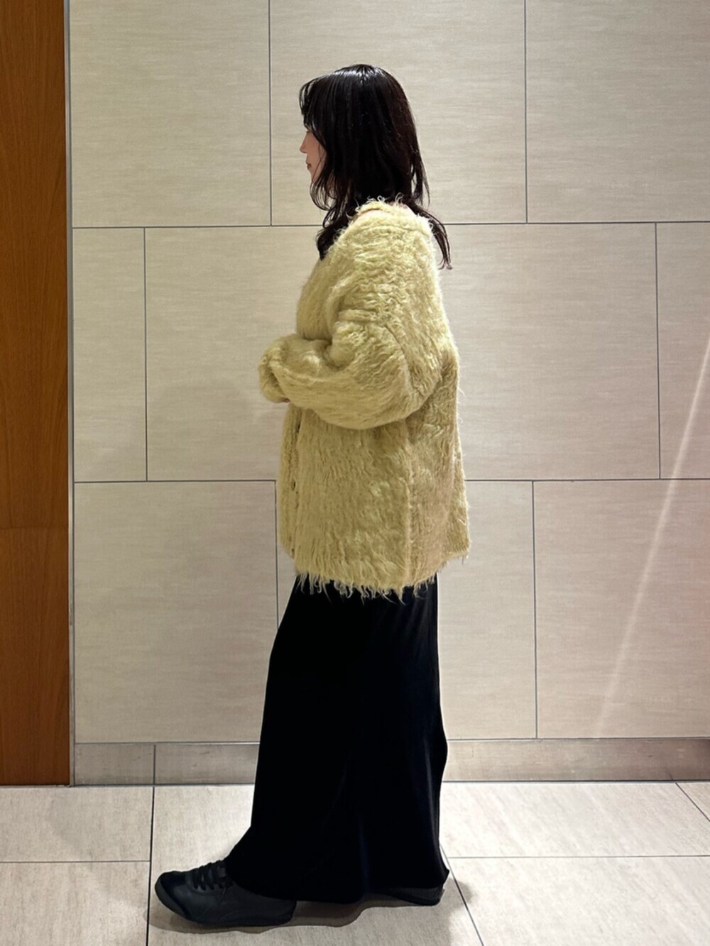 ブラック系のスカート、イエロー系のカーディガン/ボレロを着用したレディースの秋コーディネートの3枚目の写真