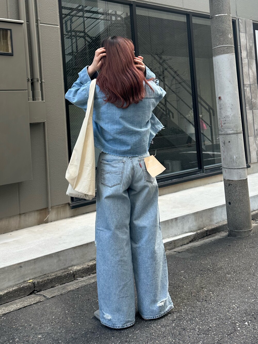 ブルー系のシャツ/ブラウス、ブルー系のデニムパンツ、ホワイト系のエコバッグ/サブバッグを着用したレディースの冬コーディネートの5枚目の写真