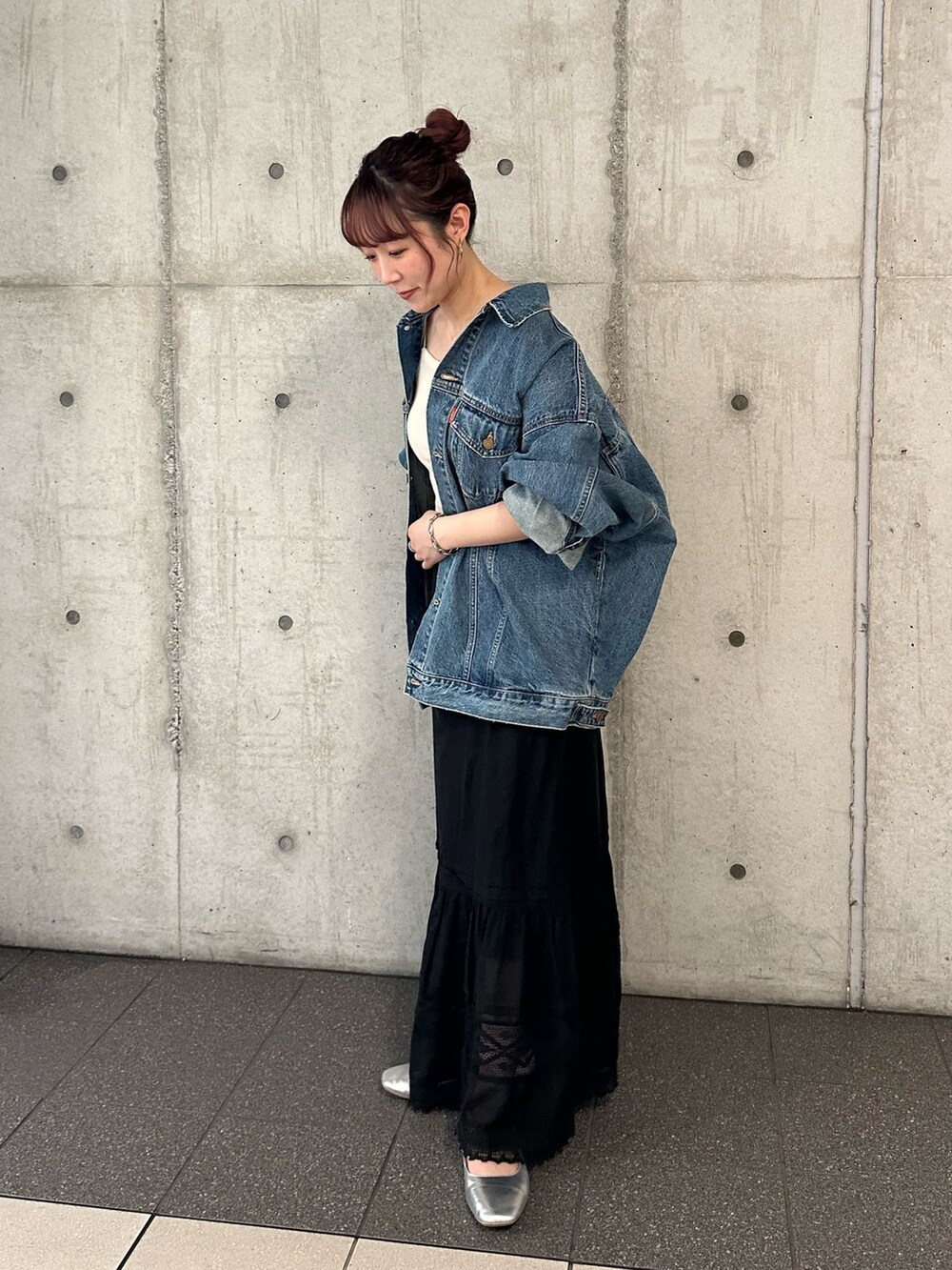 ブルー系のデニムジャケット、ブラック系のスカートを着用したレディースの夏コーディネートの5枚目の写真