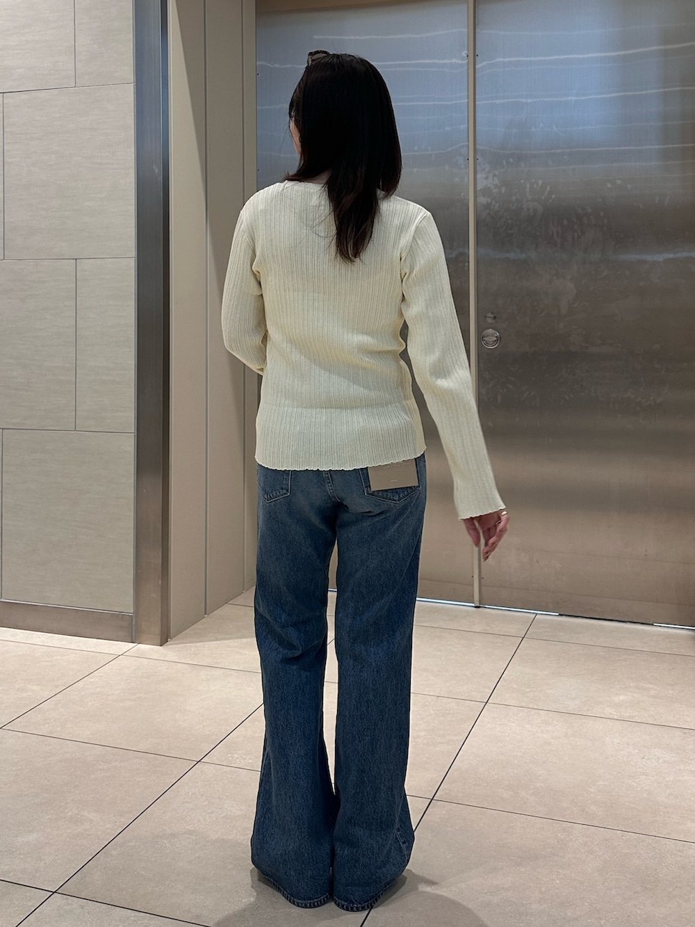 ホワイト系のカーディガン/ボレロ、ブルー系のデニムパンツを着用したレディースの冬コーディネートの5枚目の写真