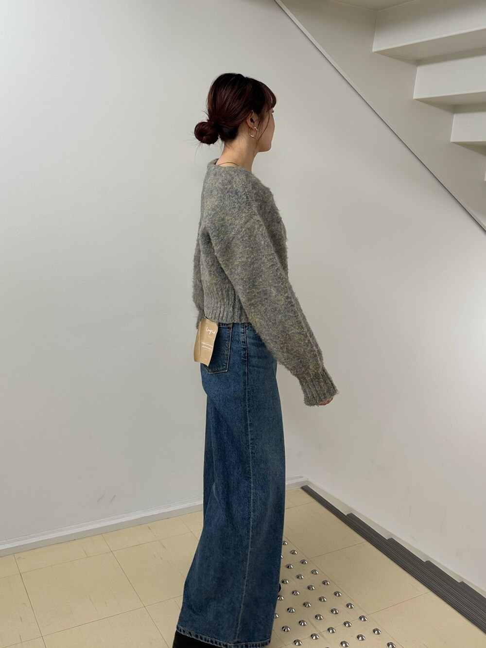 ブルー系のデニムパンツ、グレー系のカーディガン/ボレロを着用したレディースの冬コーディネートの3枚目の写真