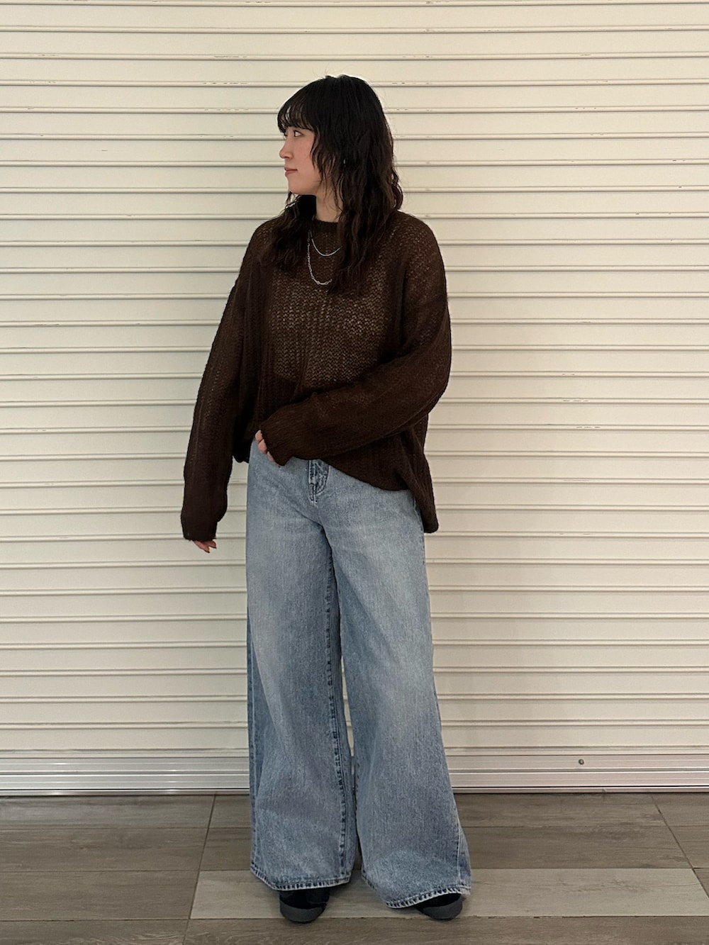 ブラウン系のニット/セーター、ブルー系のデニムパンツを着用したレディースの秋コーディネートの5枚目の写真