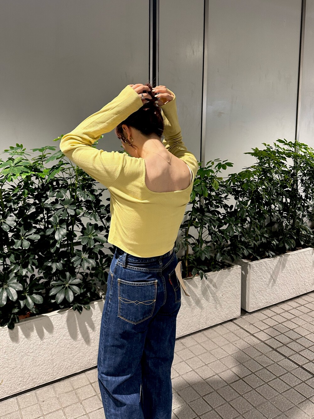 グリーン系のTシャツ/カットソー、ブルー系のデニムパンツを着用したレディースの秋コーディネートの4枚目の写真