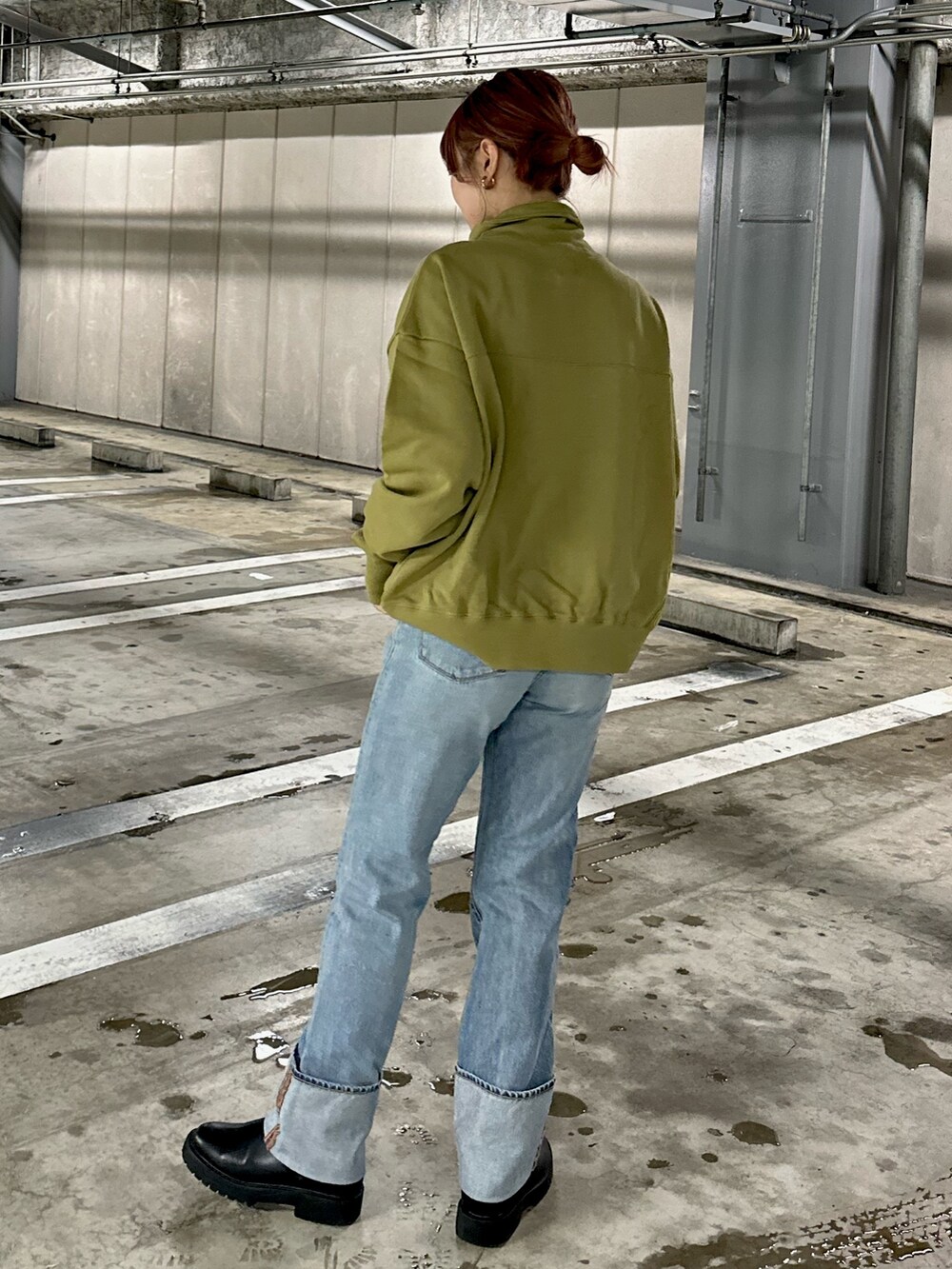 グリーン系のスウェット、ブルー系のデニムパンツを着用したレディースの冬コーディネートの2枚目の写真