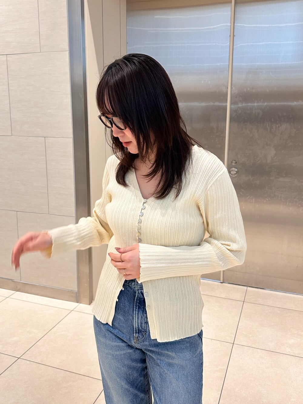 ホワイト系のカーディガン/ボレロ、ブルー系のデニムパンツを着用したレディースの冬コーディネートの6枚目の写真