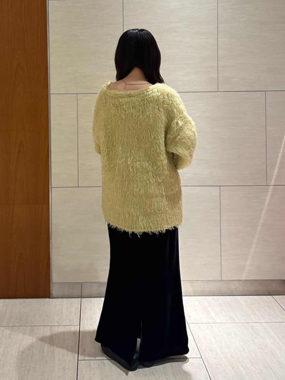 ブラック系のスカート、イエロー系のカーディガン/ボレロを着用したレディースの秋コーディネートの4枚目の写真