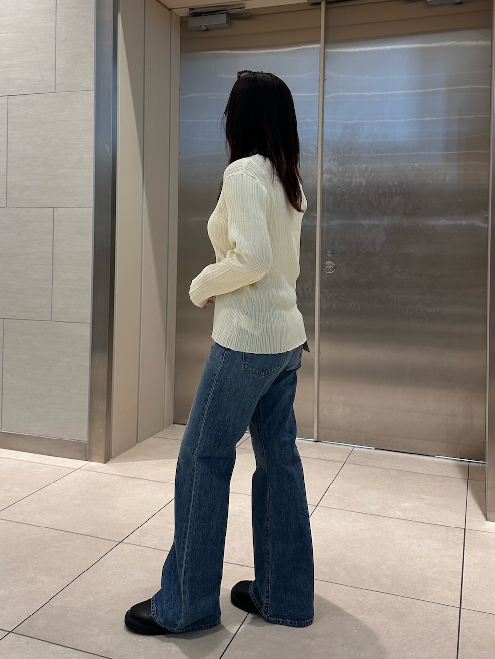 ホワイト系のカーディガン/ボレロ、ブルー系のデニムパンツを着用したレディースの冬コーディネートの3枚目の写真