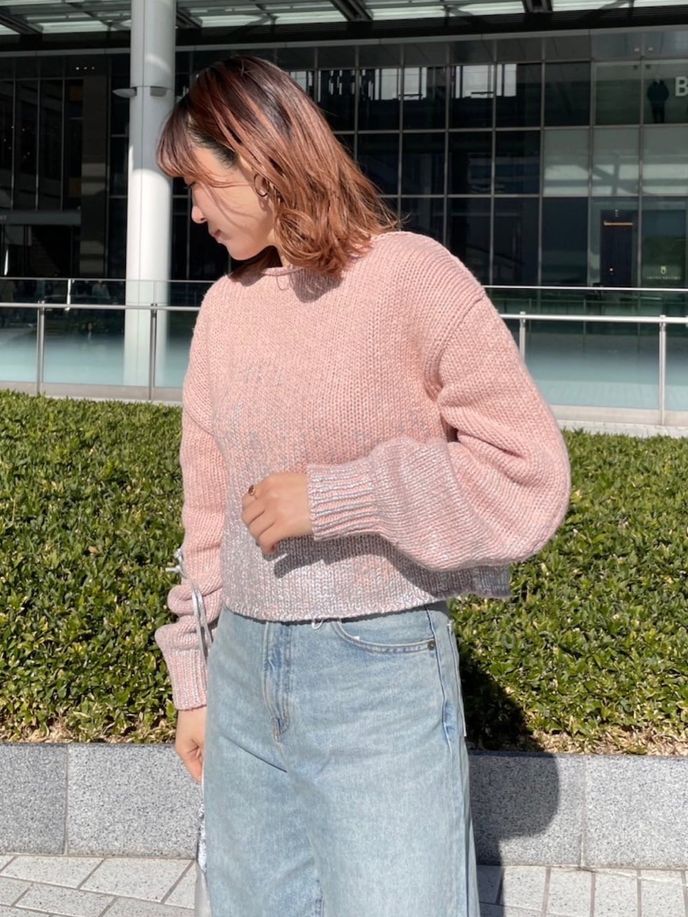 ピンク系のニット/セーター、ブルー系のデニムパンツを着用したレディースの冬コーディネートの4枚目の写真