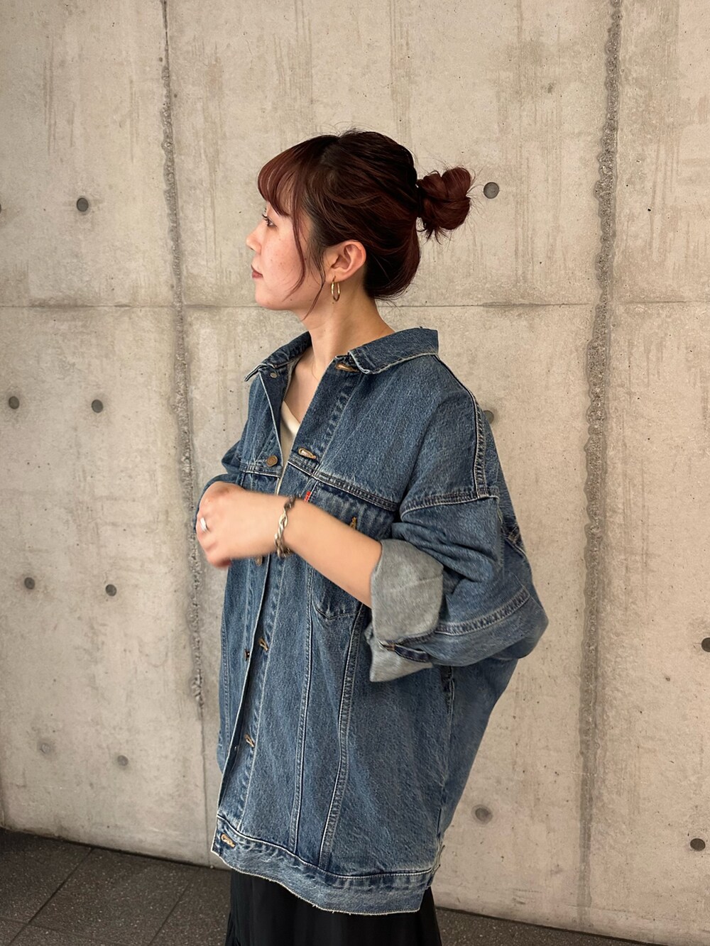 ブルー系のデニムジャケット、ブラック系のスカートを着用したレディースの夏コーディネートの6枚目の写真