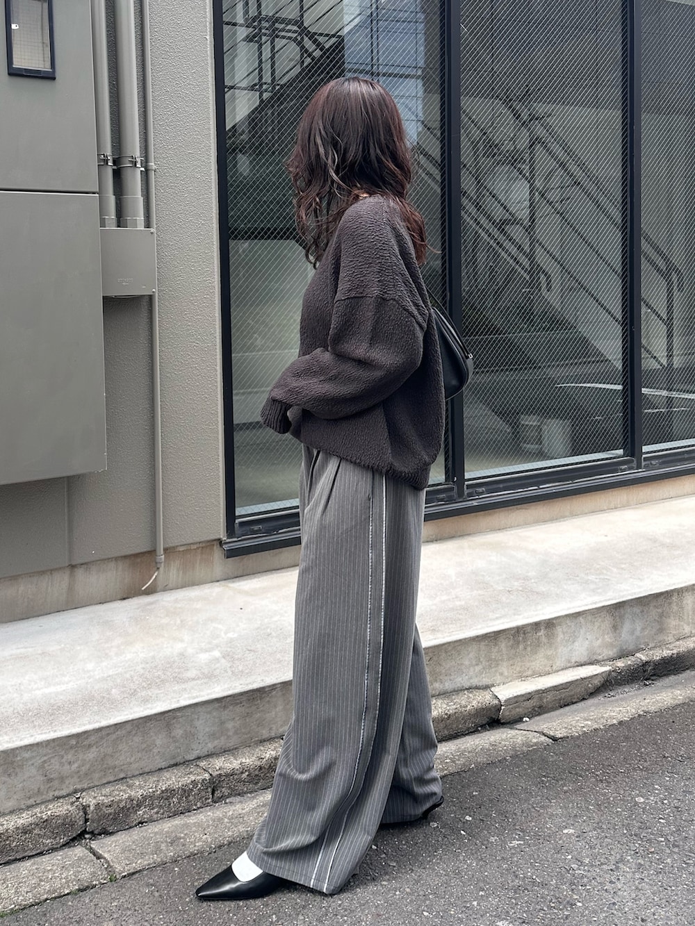 グレー系のニット/セーター、グレー系のその他パンツを着用したレディースの冬コーディネートの3枚目の写真