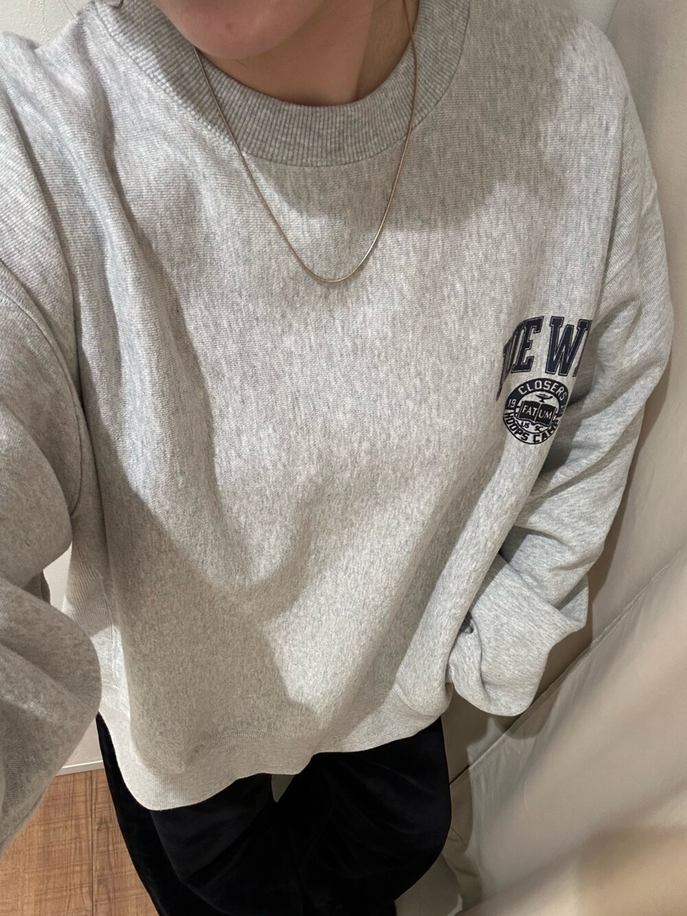 グレー系のスウェット、ブラック系のデニムパンツを着用したレディースの秋コーディネートの6枚目の写真