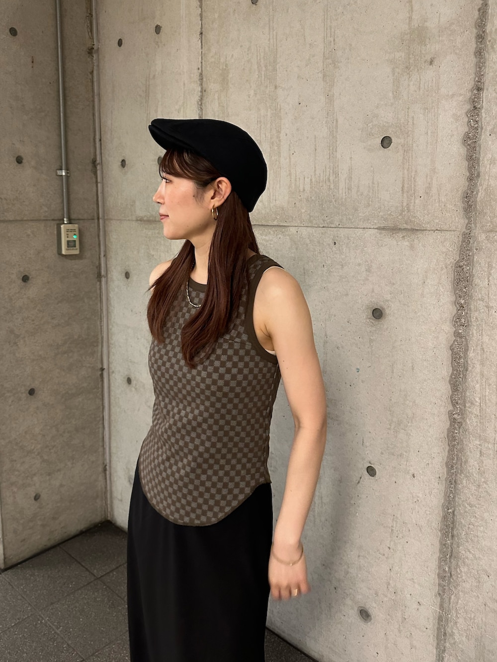 ブラウン系のタンクトップ、ブラック系のスカート、ブラック系のハンチング/ベレー帽を着用したレディースの春コーディネートの6枚目の写真