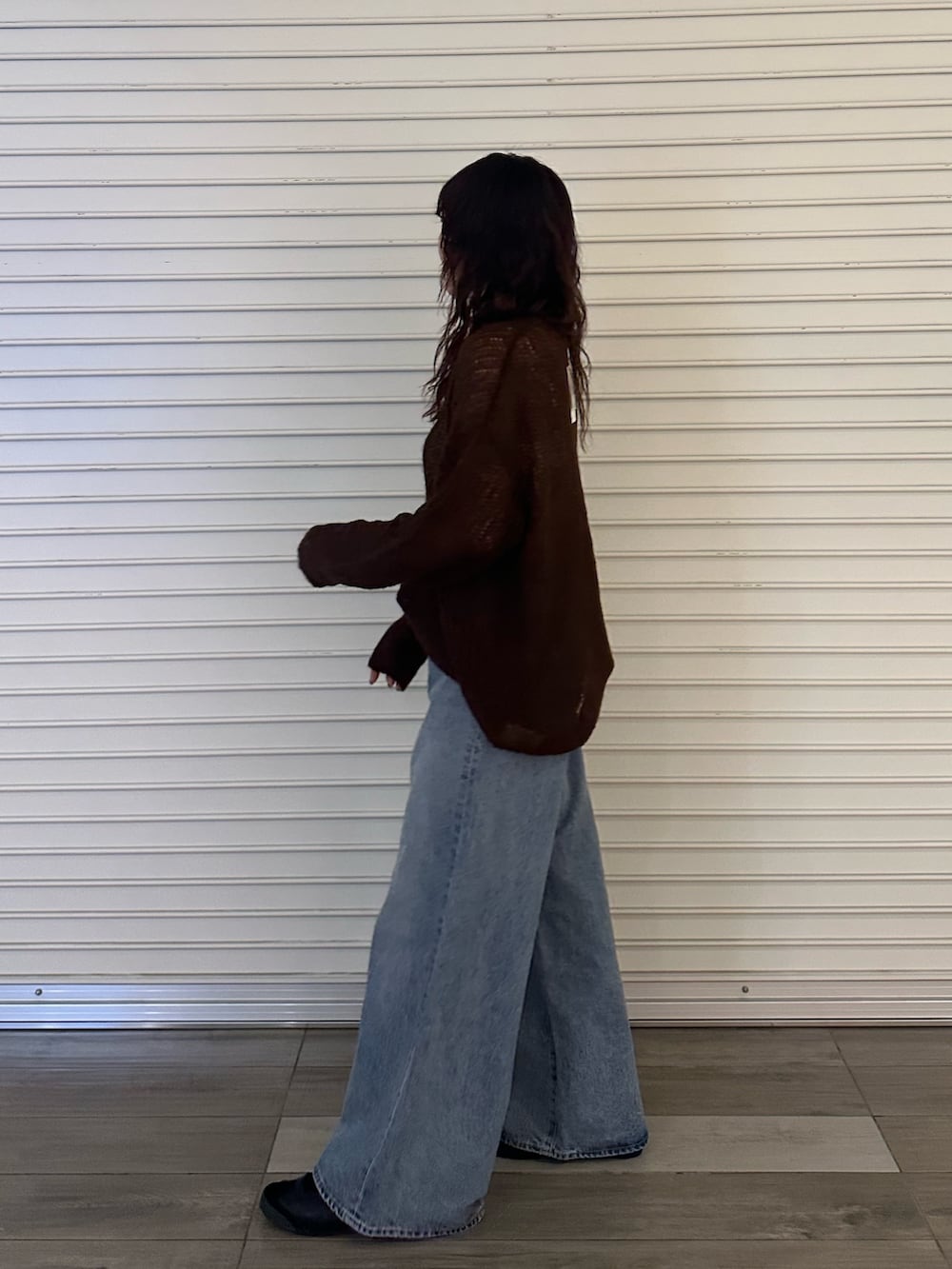 ブラウン系のニット/セーター、ブルー系のデニムパンツを着用したレディースの秋コーディネートの3枚目の写真