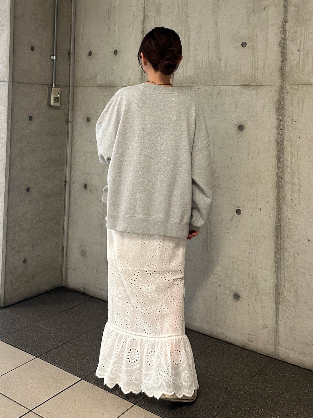 グレー系のスウェット、ホワイト系のスカートを着用したレディースの冬コーディネートの5枚目の写真