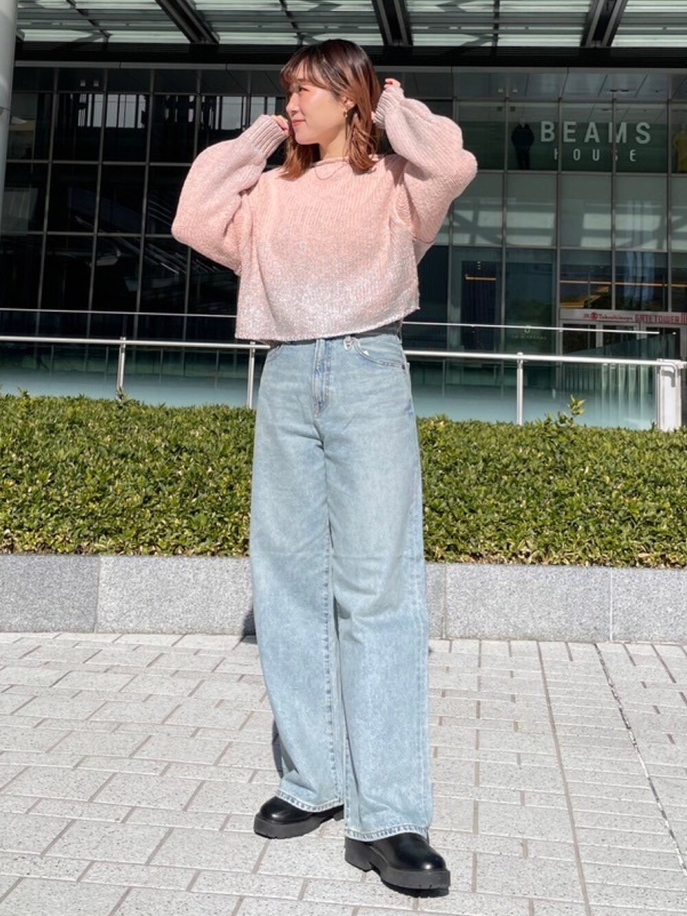 ピンク系のニット/セーター、ブルー系のデニムパンツを着用したレディースの冬コーディネートの2枚目の写真