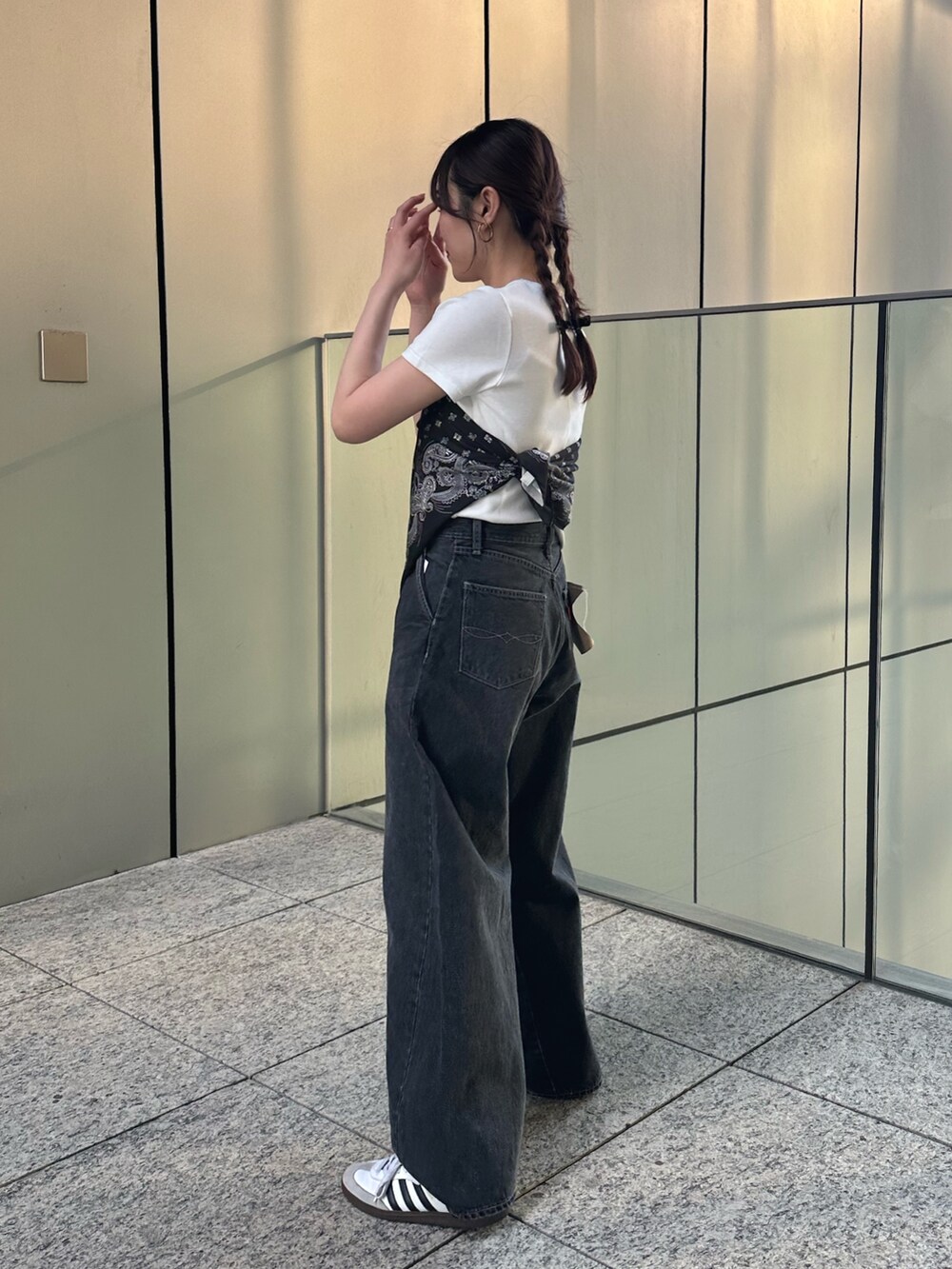 ホワイト系のTシャツ/カットソー、ブラック系のデニムパンツ、ブラック系のストール/ショールを着用したレディースの春コーディネートの3枚目の写真