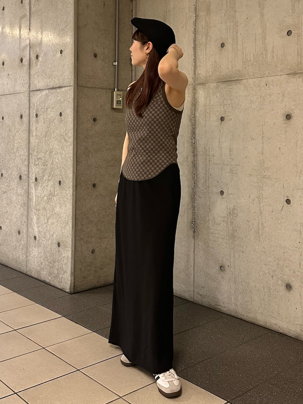 ブラウン系のタンクトップ、ブラック系のスカート、ブラック系のハンチング/ベレー帽を着用したレディースの春コーディネートの2枚目の写真