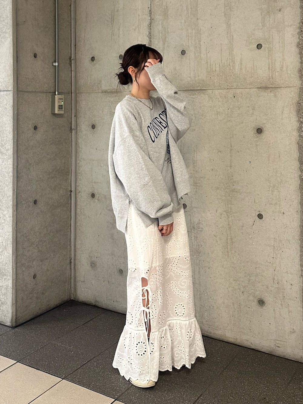 グレー系のスウェット、ホワイト系のスカートを着用したレディースの冬コーディネートの4枚目の写真